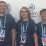 Terrell Washington, Cass Moquett, and Liam Connally pose in front of the EAST conference entrance