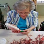 Pat Morales, a very faithful Volunteer, assists many of the residents with their craft projects.