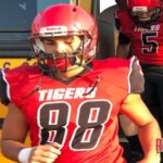 Colton Stipins leads the MHS Tigers from the bus to the field